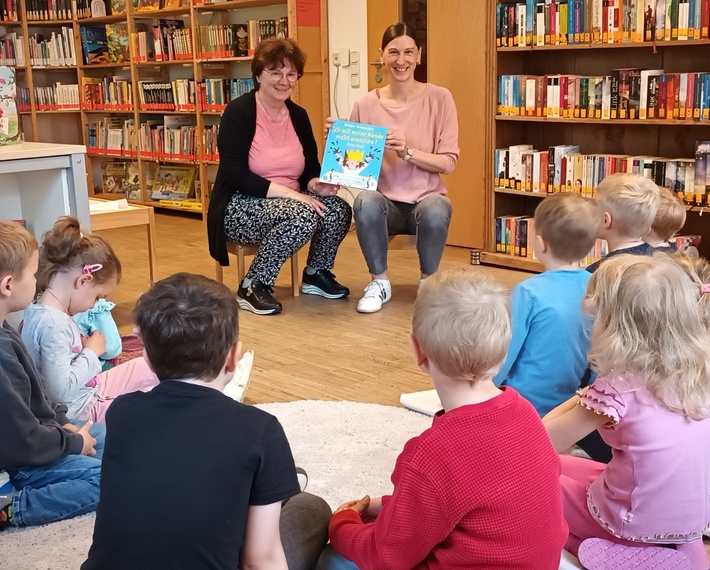 Büchereimitarbeiterinnen lesen Kindergartenkinder vor
