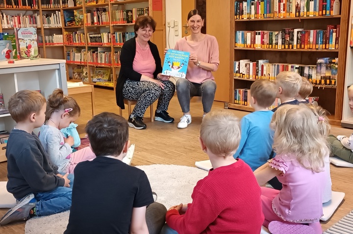 Büchereimitarbeiterinnen lesen Kindergartenkinder vor